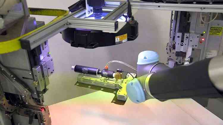 The UR5 places the fabric under a camera lens for quality inspection © Universal Robots
